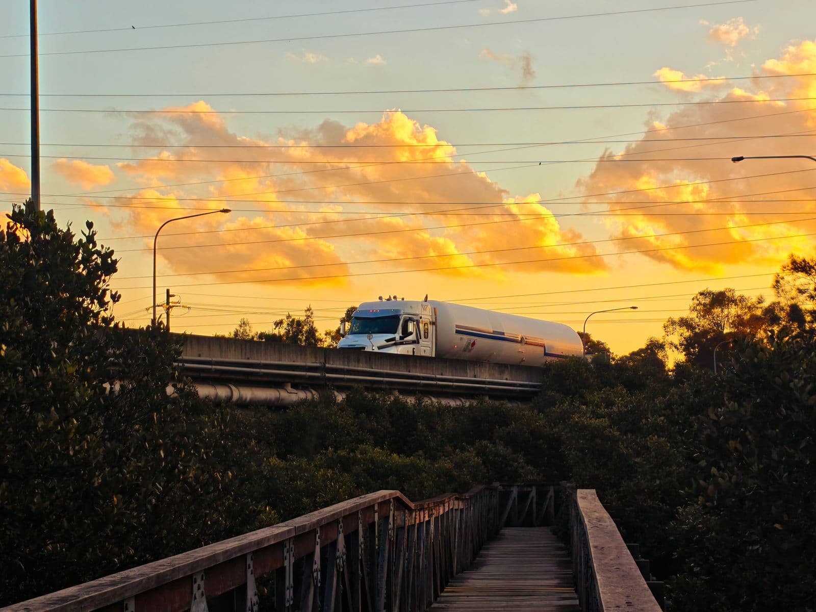 A road tanker crossing a highway viaduct.