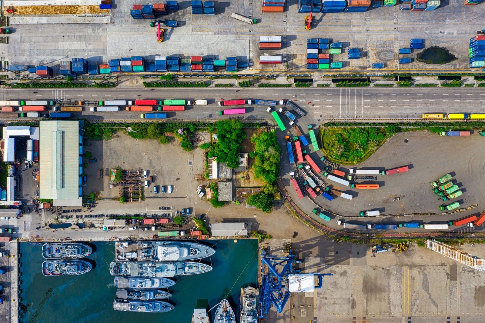 Aerial view of a port where a container yard, truck lanes and quayside berths meet.