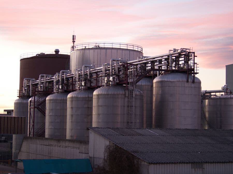 Stainless steel process tanks and pipework at a chemical storage facility.