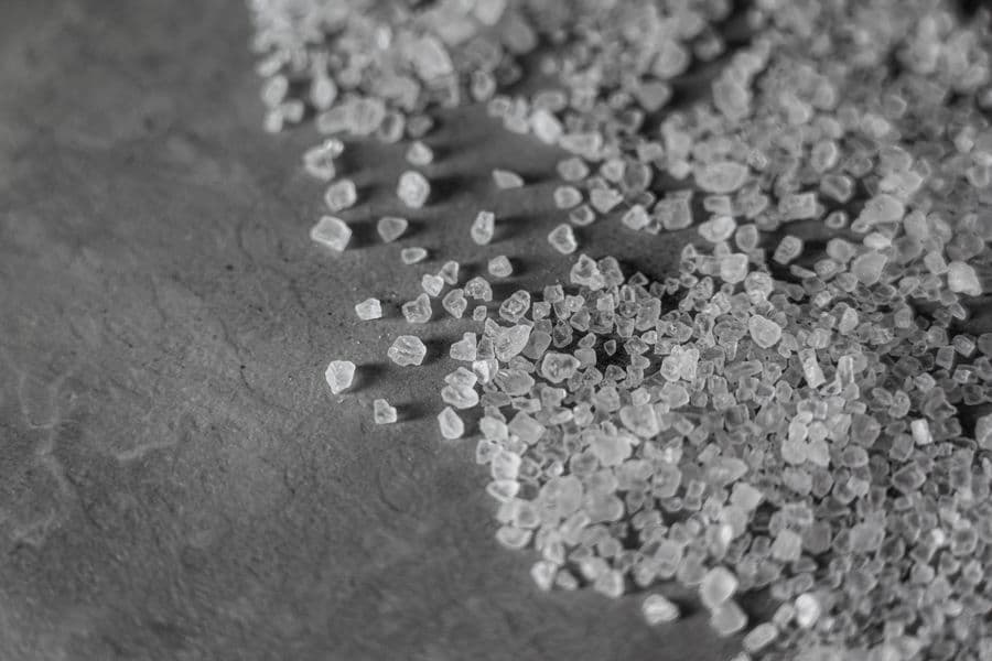 Coarse mineral crystals scattered across a dark stone surface.