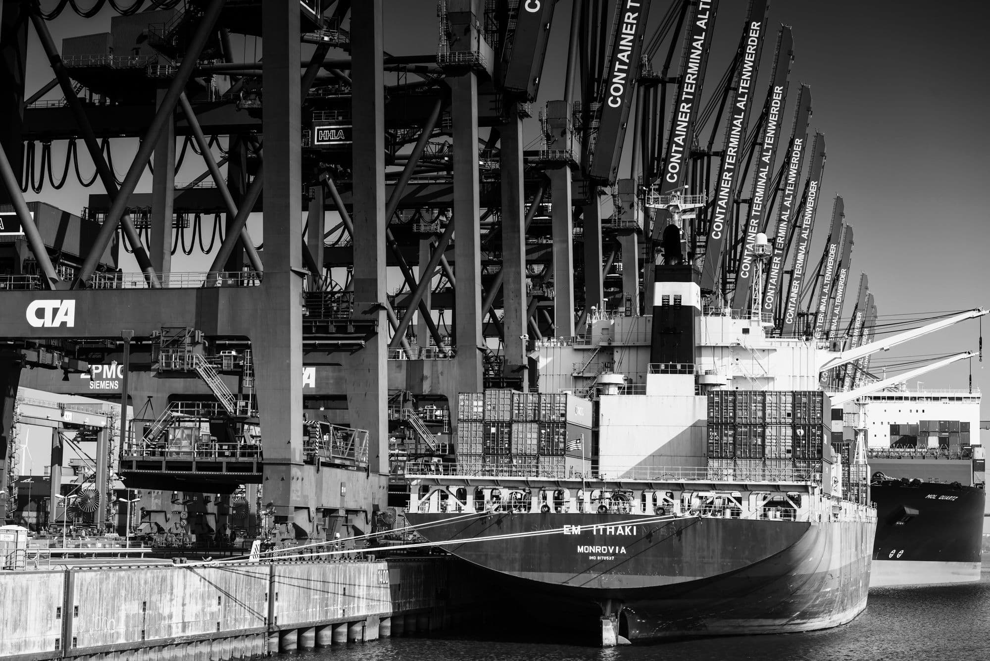 Gantry cranes working a vessel at a deep-sea container terminal.